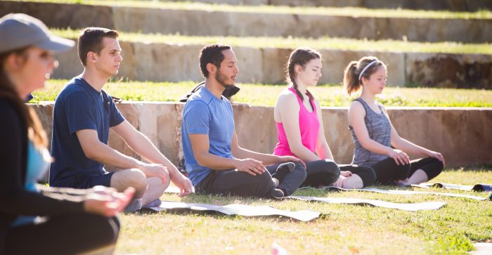 Students meditate on the outdoor amphitheater lawn at A&M-Commerce