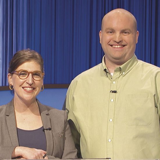 Two people shake hands and pose for a photo