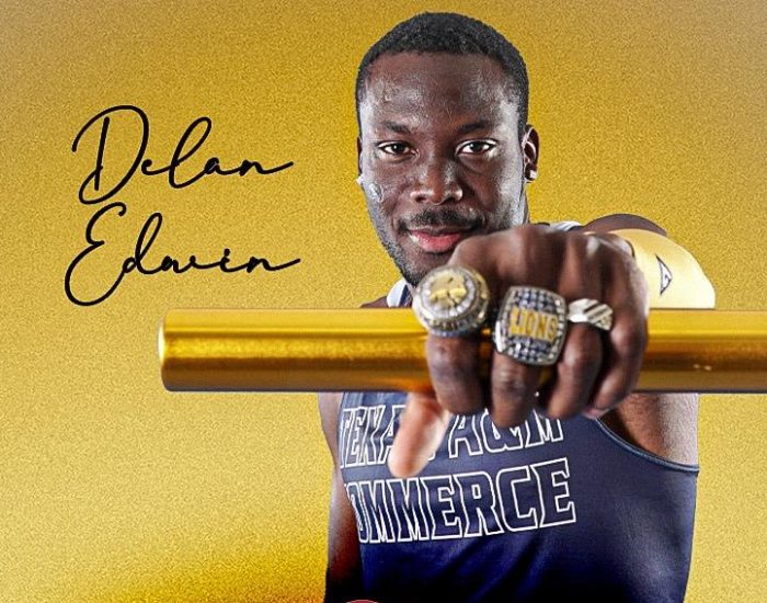 Athlete holds arm out in front of him to show hand with three school rings on his fingers.