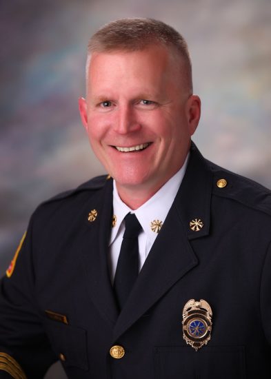 Frisco Fire Chief smiles in headshot photo.