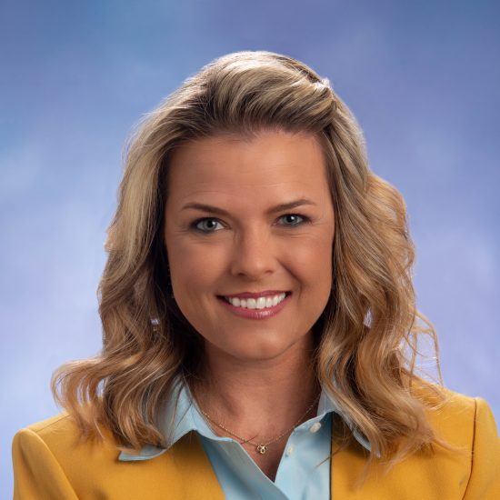 Head shot of Amanda Horne in yellow jacket and blue button-down shirt.