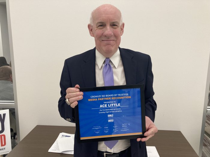 Person holds certificate and smiles into the camera.