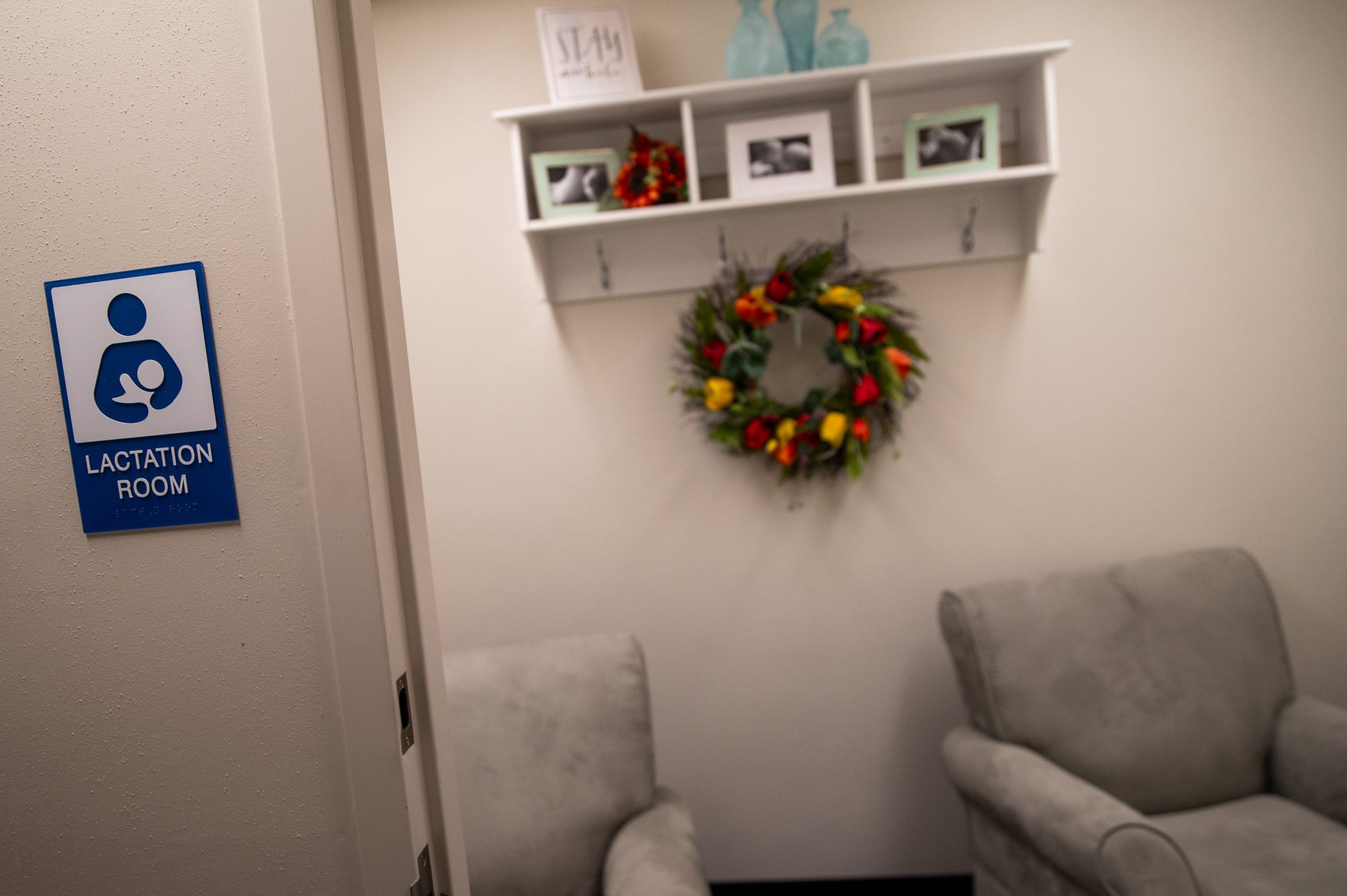 A room with two chairs and a sign that says lactation room.