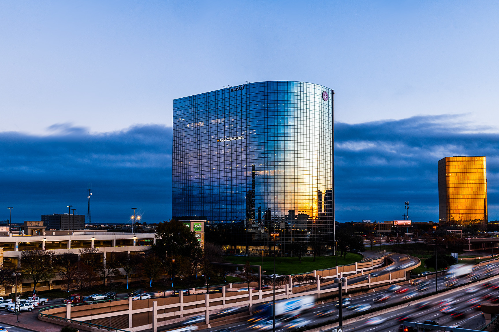 High rise building in Dallas stands beside busy freeway.