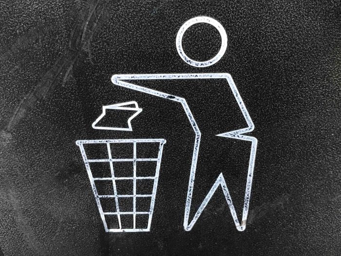 Line drawing of figure throwing trash in the bin