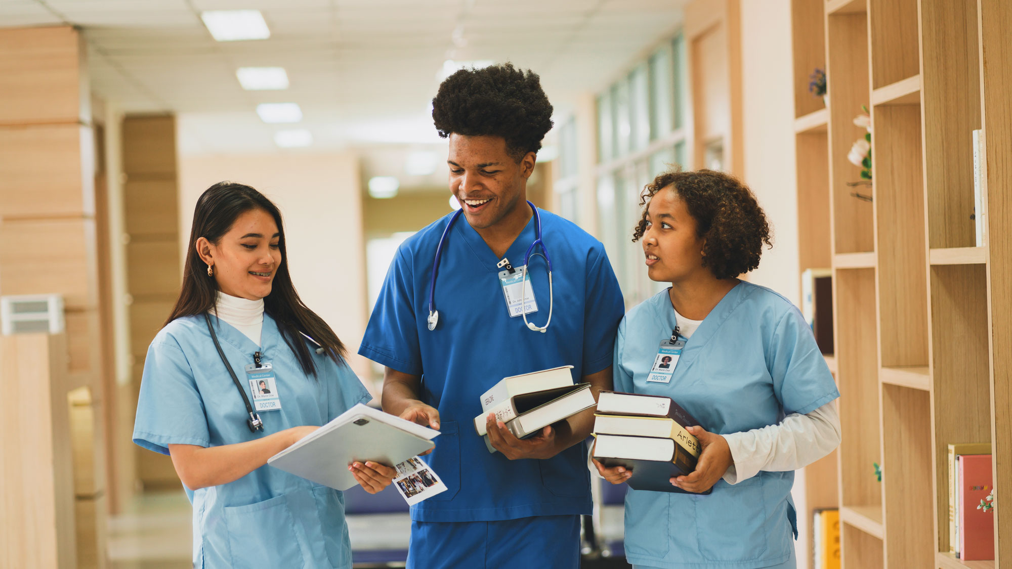 Nursing students at the hospital  and pointing to papers.