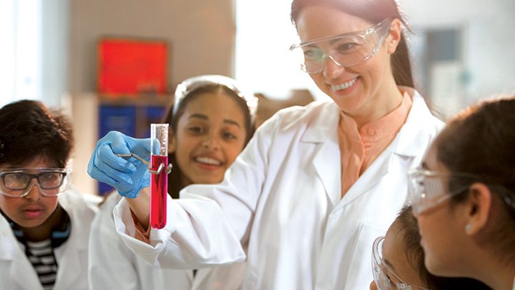 A female science teacher showing an experiment to children.