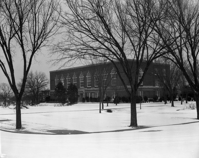 A black and white photograph of David Talbot Hall, a brick building with windows on all sides.