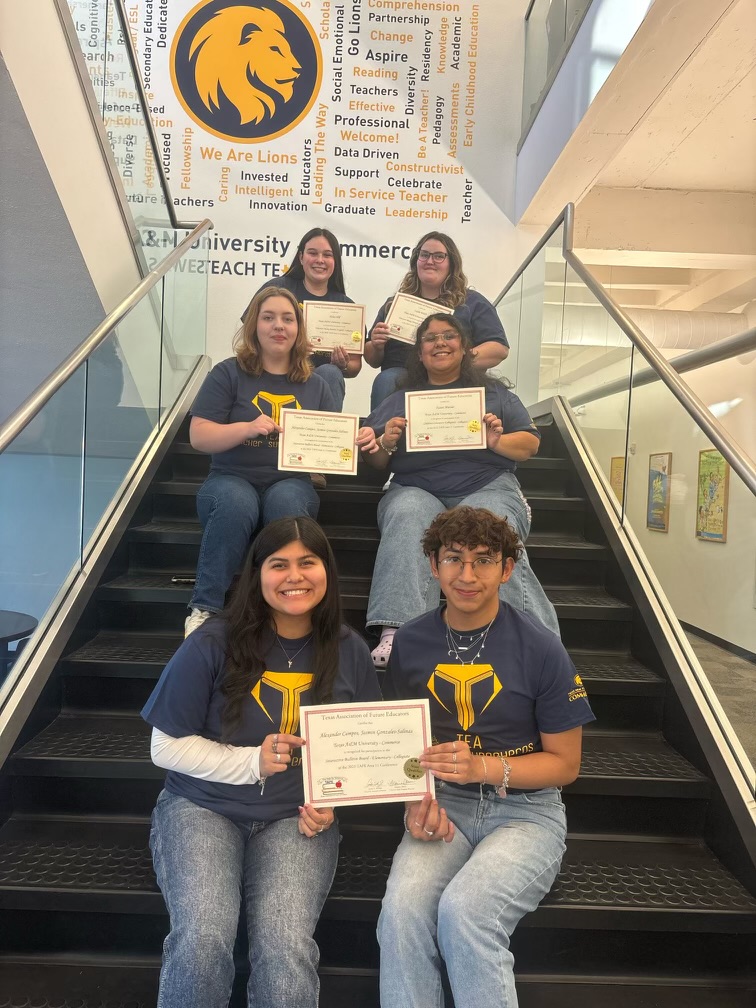 Six students holding certificates sit on a staircase in three rows of two.