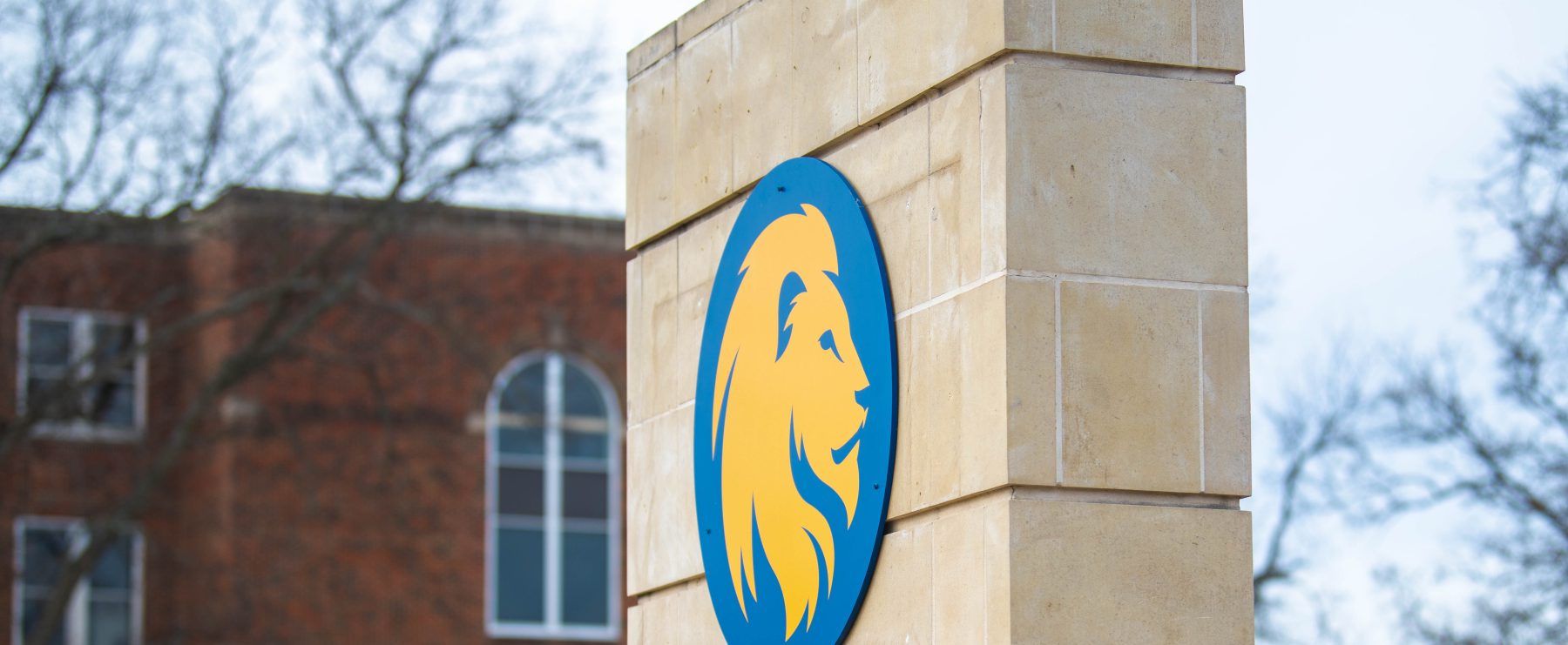 A vertical stone pillar displays the A&M-Commerce logo.