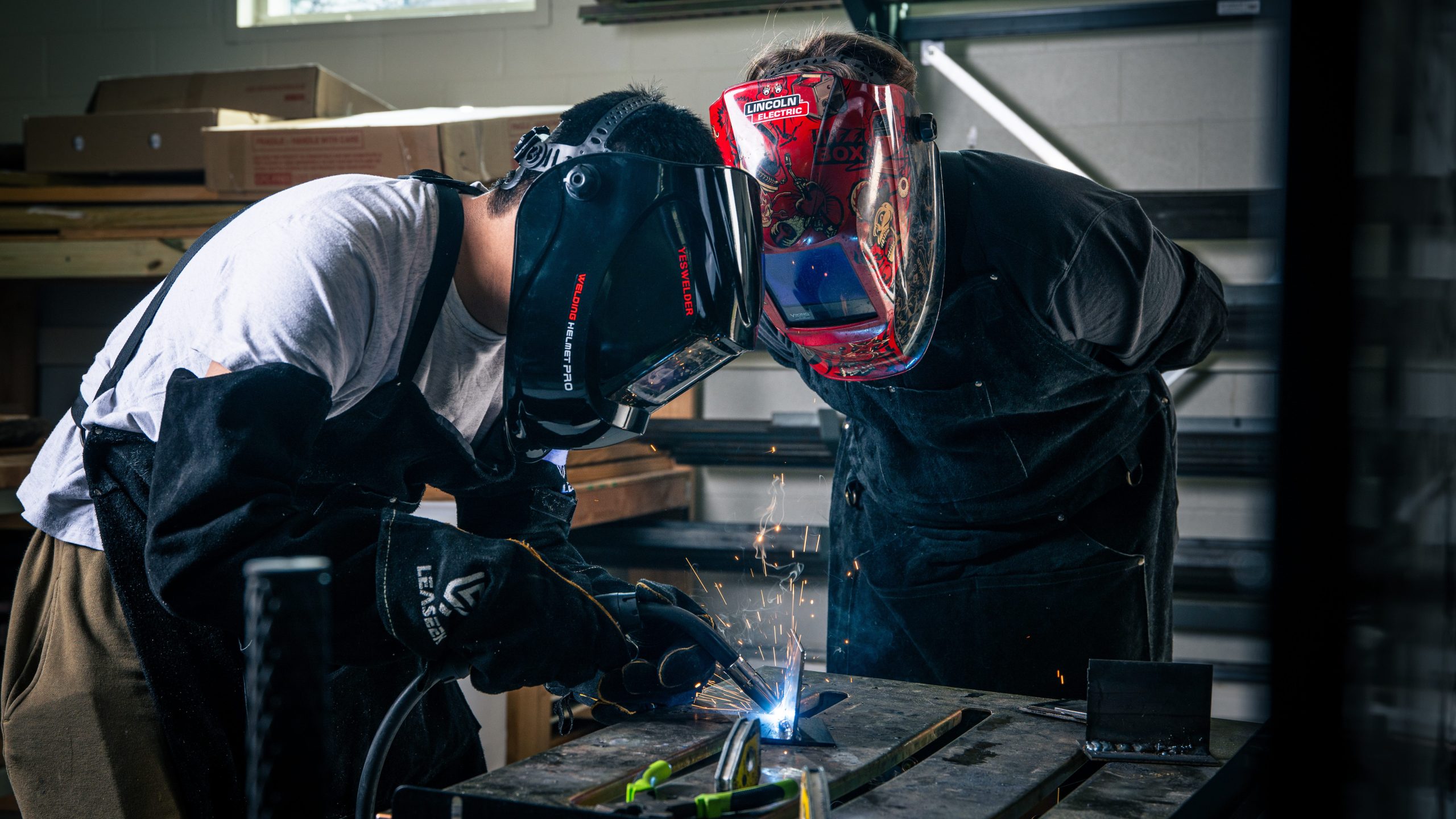 Two males working on a machine. 