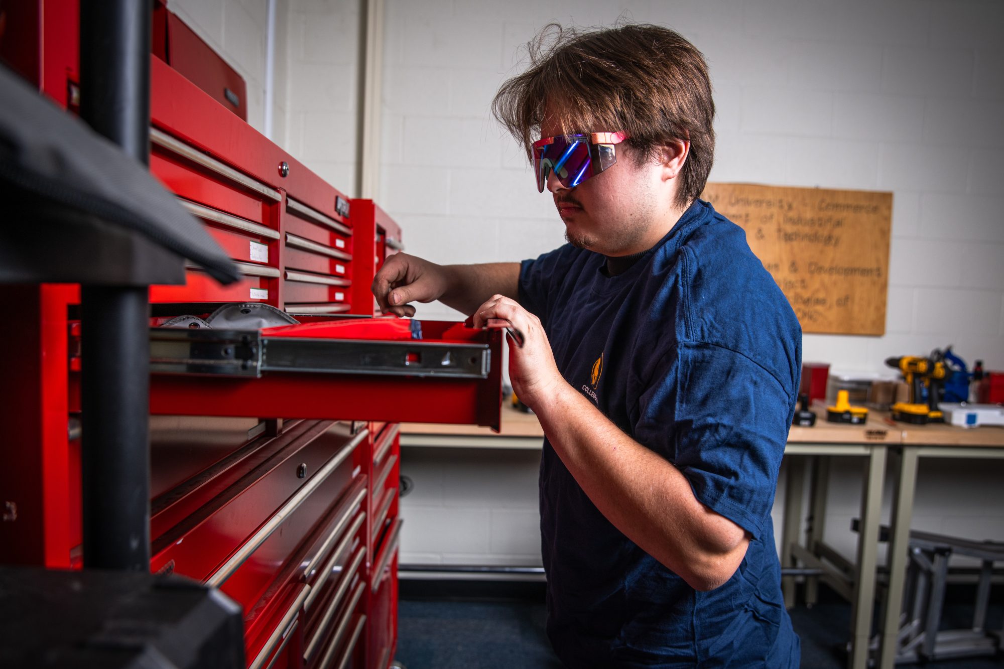 A male looking through a tool case.