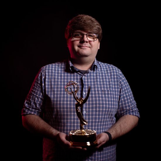 A photo of a person holding a golden trophy.