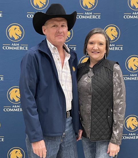 Scott and Margaret pose for a photo in front of an A&M-Commerce backdrop.