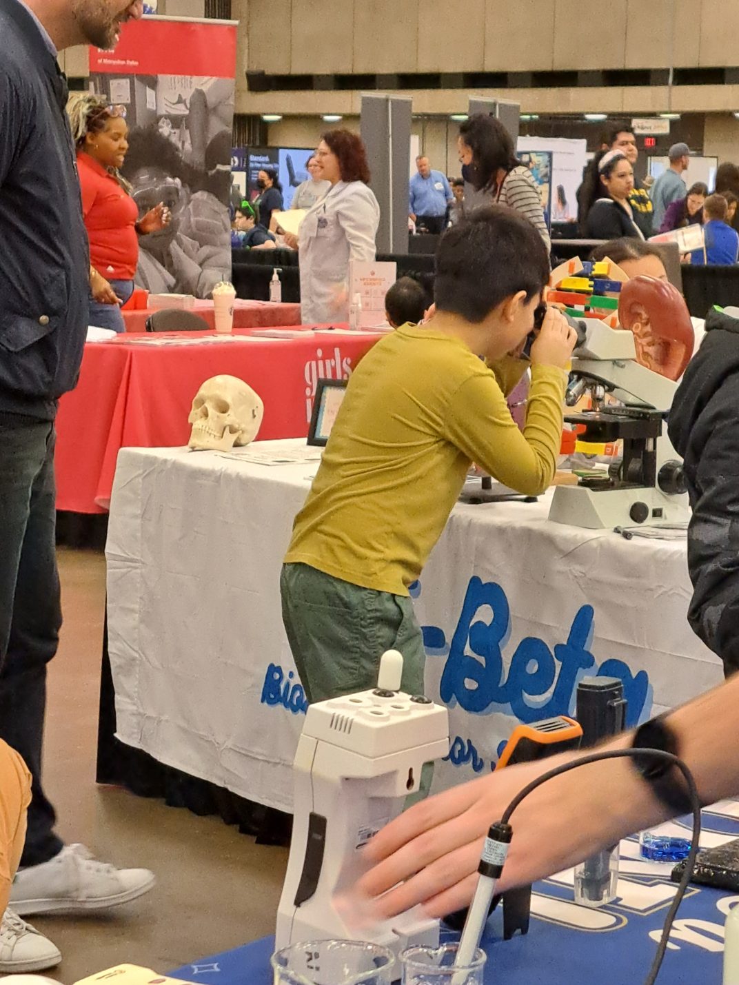 A young boy peers into a microscope.