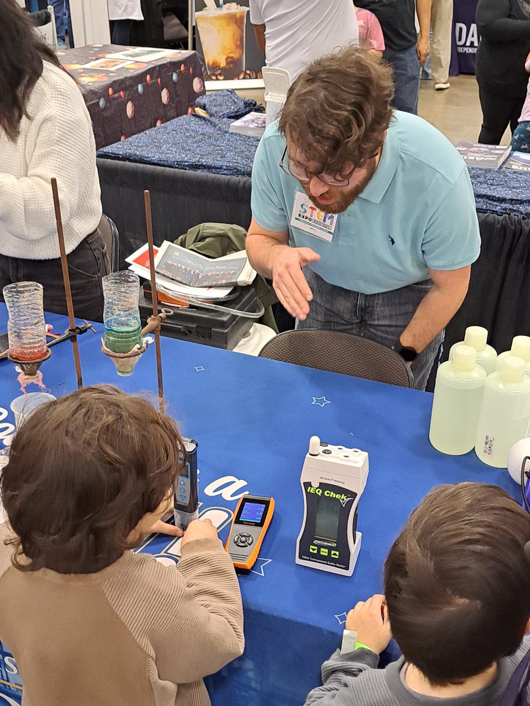 College students displaying various science demonstrations for school-age students.