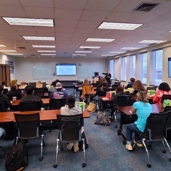 A classroom full of people listening to a presentation.