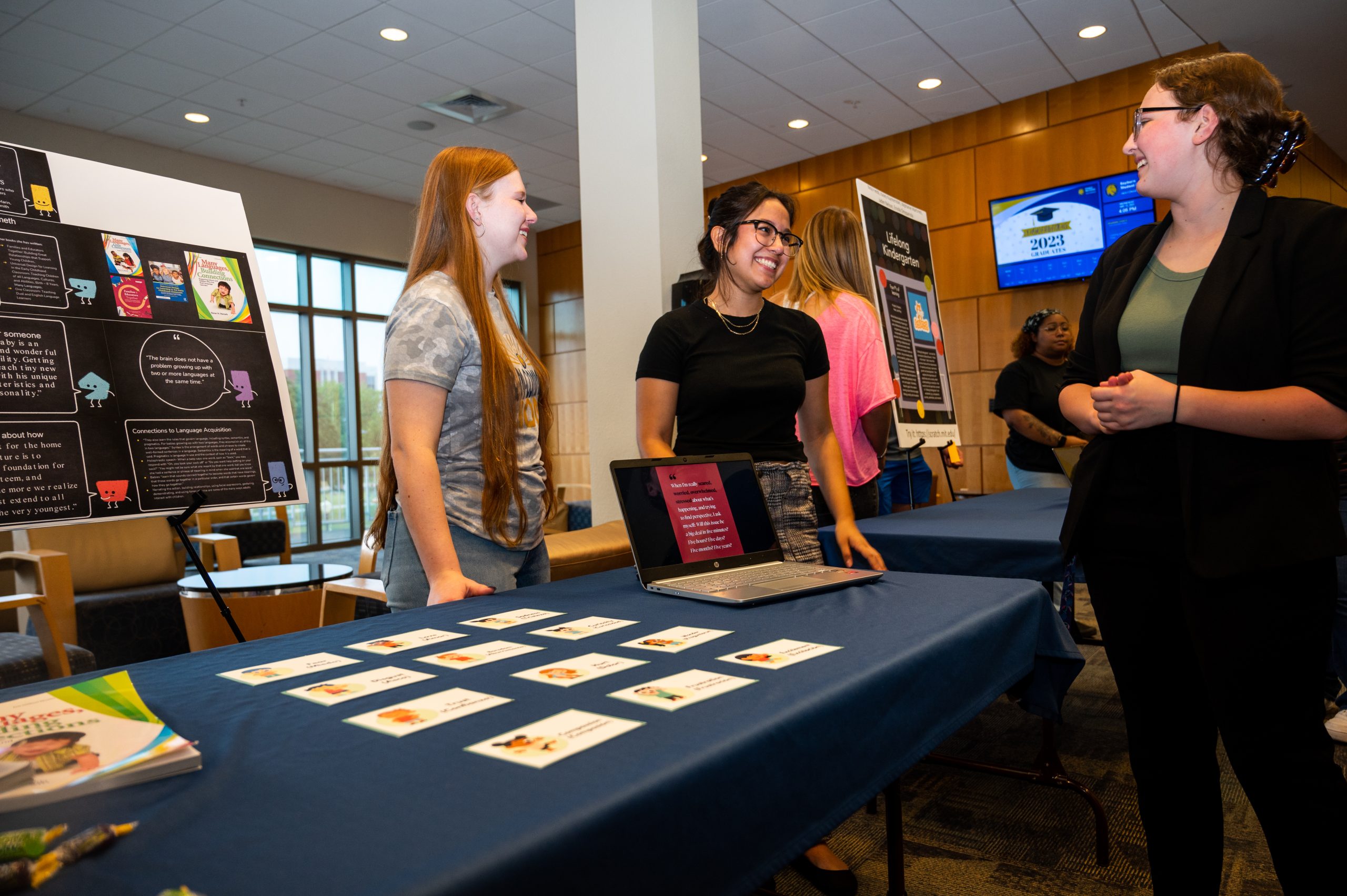 Three female student presenting at a conference.