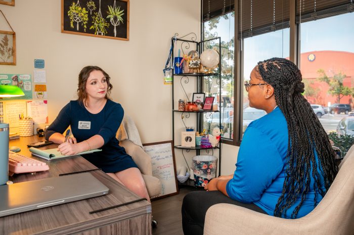 A female student speaking to a female mentor about something in an office.