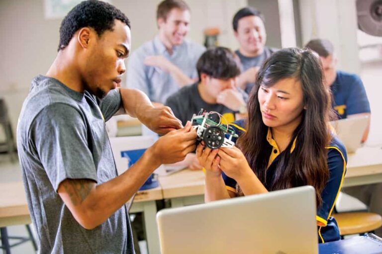 A male and female student working together to build a robot.