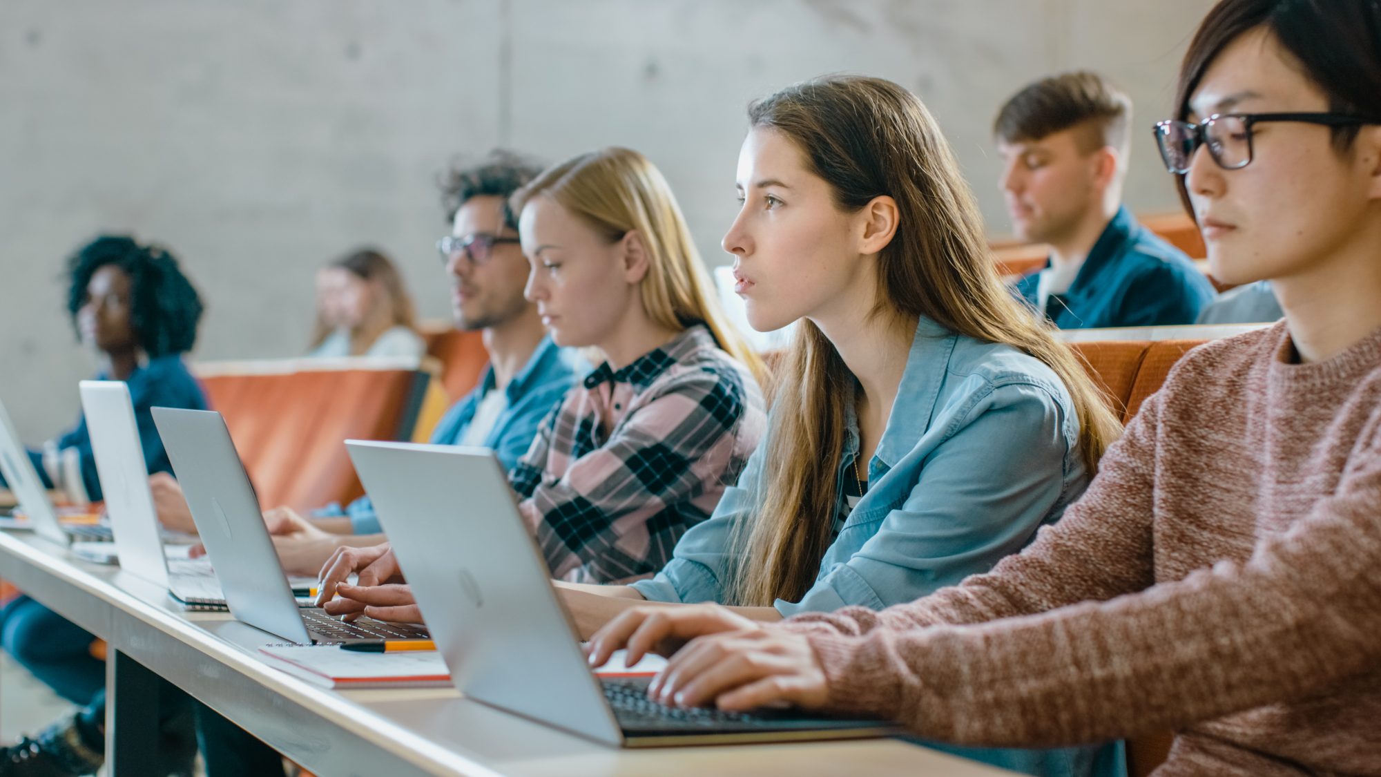 A group of students with their computers open watching in front of them.