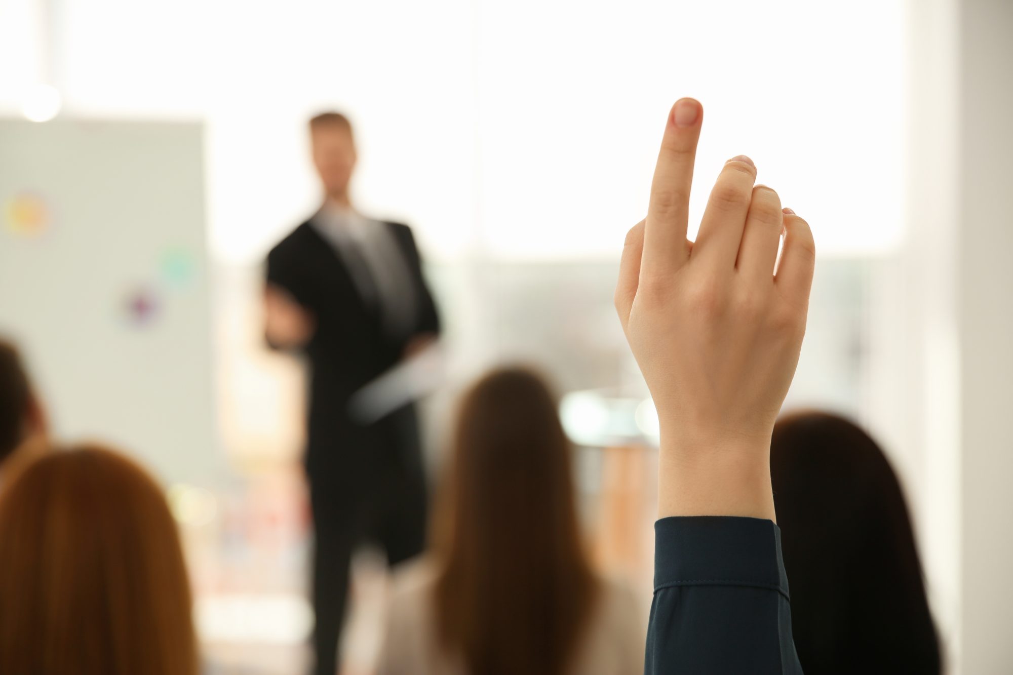 A students hand up in the air while in class.