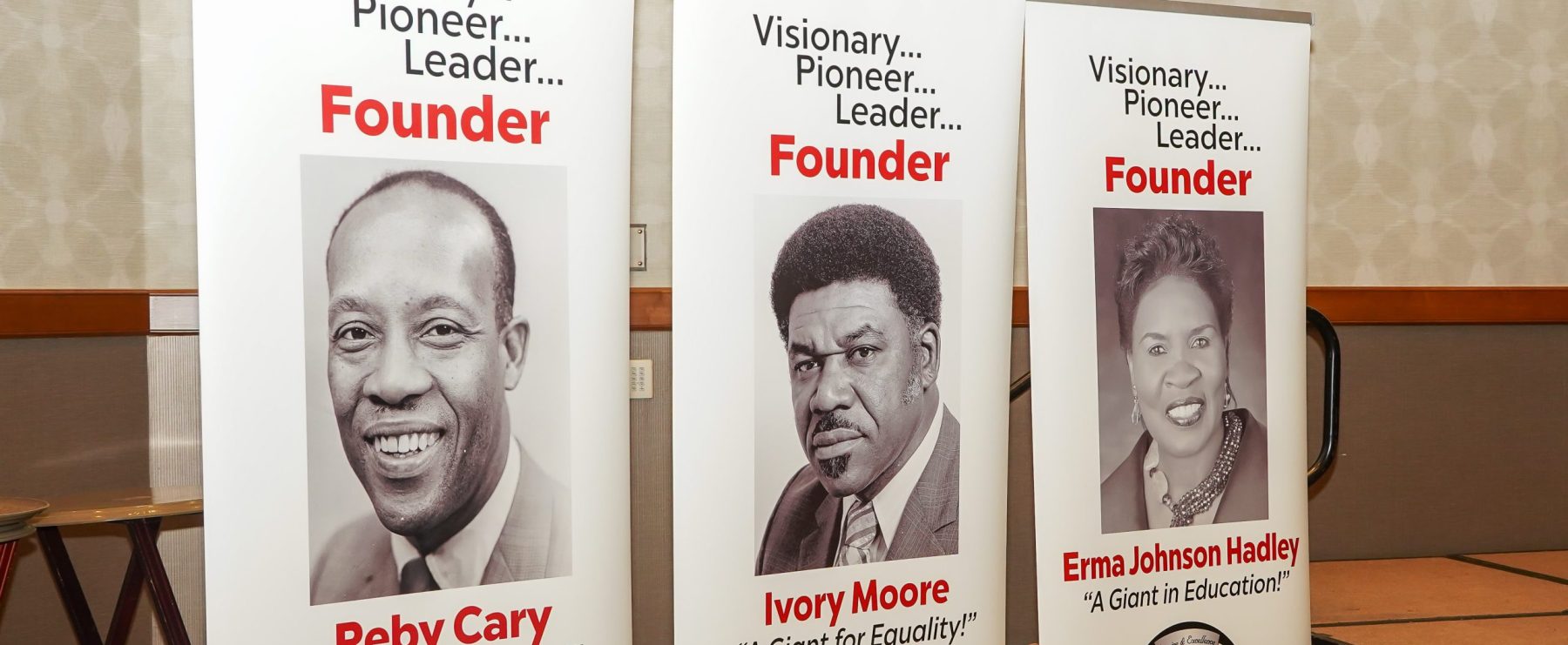 Vertical floor banners portray the three founders of the Texas Association of Black Personnel in Higher Education.