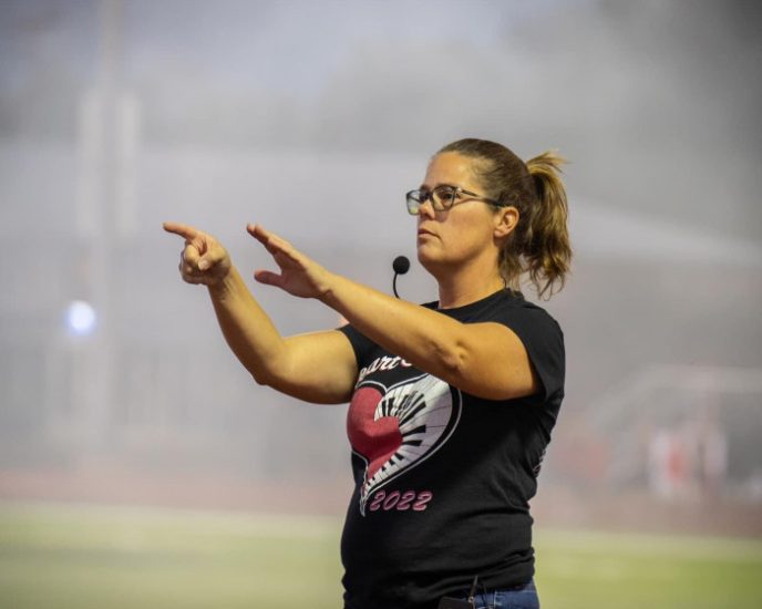 A band director issues instructions to their ensemble.