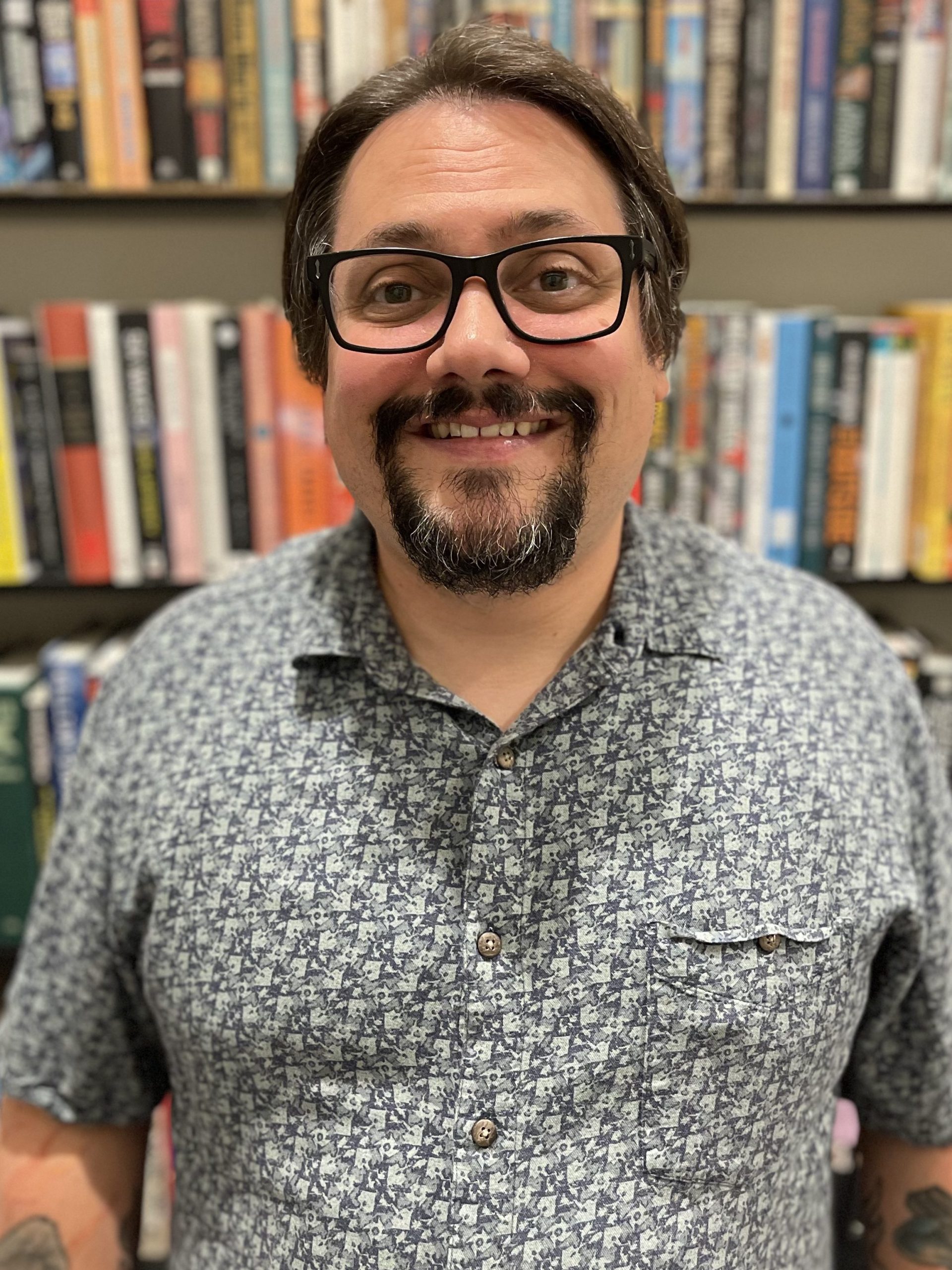 Brian McShane standing in front of bookshelves