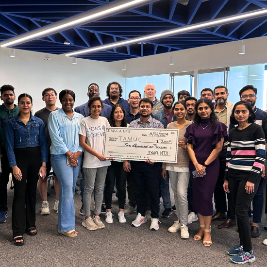 A group of people pose for a photo with an oversized novelty cheque