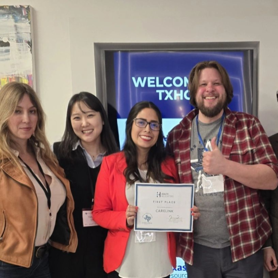 Four people pose for a photo with a certificate that reads "first place."