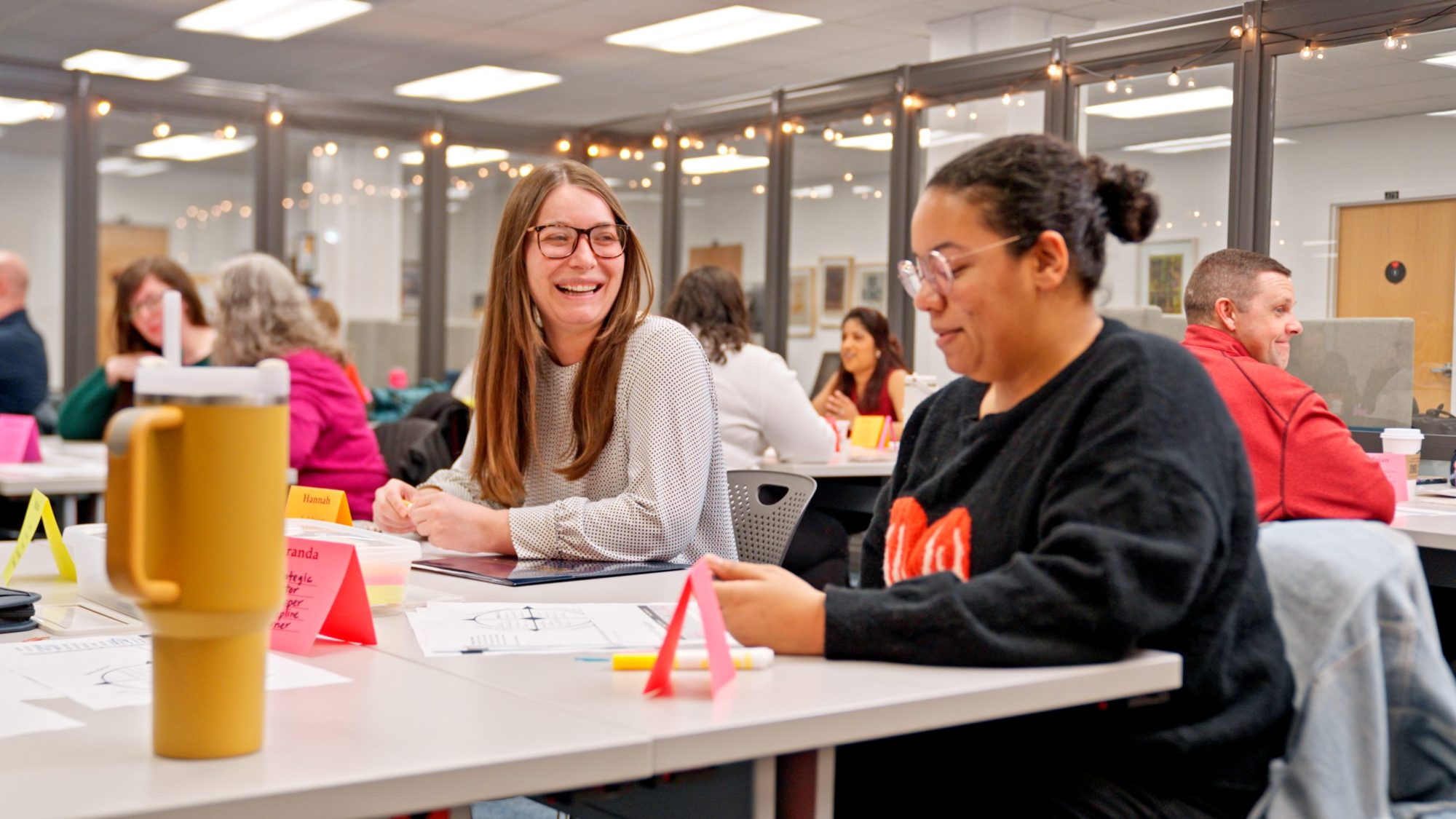 Two adult learners discuss an assignment they're working on together.