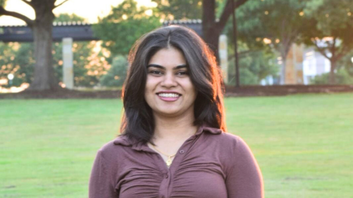 A headshot photo of a person taken outdoors.