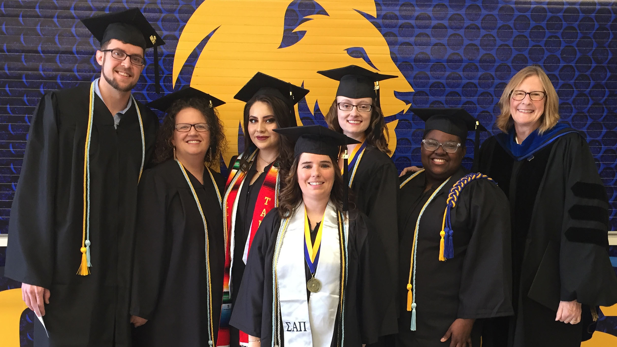 A group of graduates pose for a photo with Dr. Kit Blount (right).