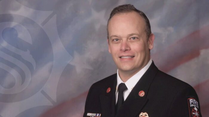 A headshot photo of a fire man in ceremonial dress